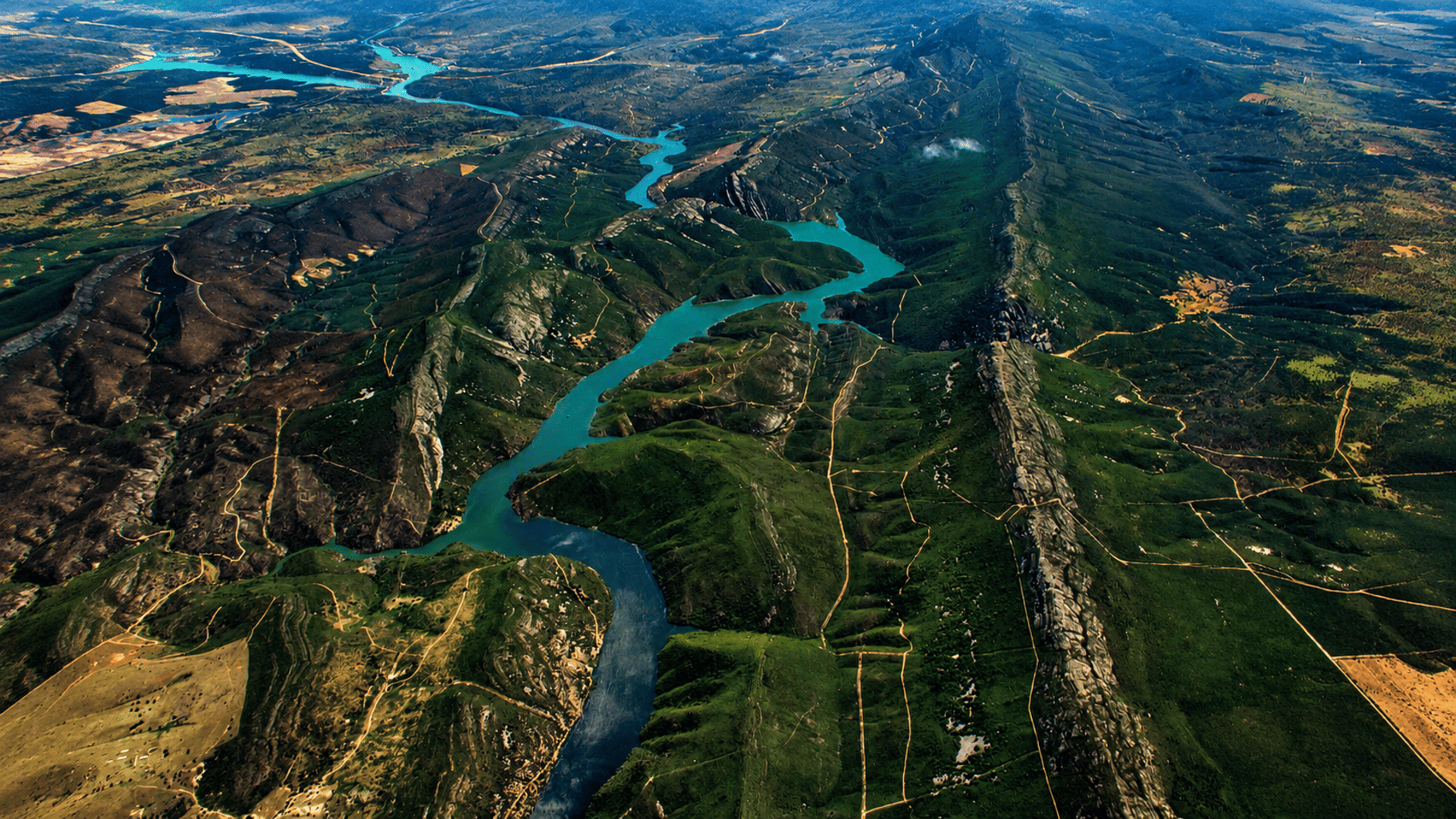 Ruta_roja_5 Vista aérea del Parque Nacional de Monfragüe con el río serpenteando entre sierras y laderas verdes.